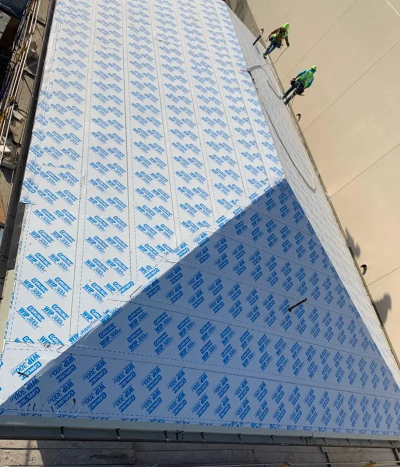 Professional roofers installing underlayment on a metal roof in Tarboro